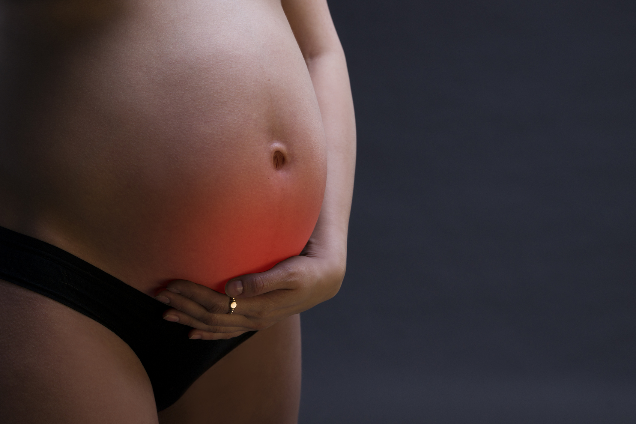 těhotná žena s bolestmi podbřišku